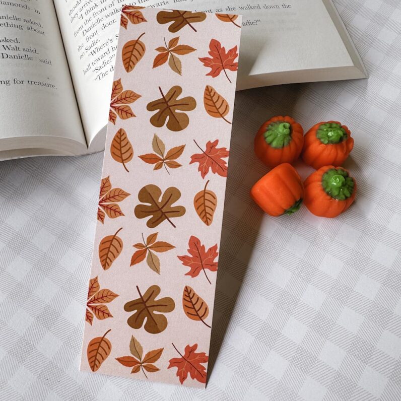 Various varieties of fall leaves in orange, tan, and brown on a white background.