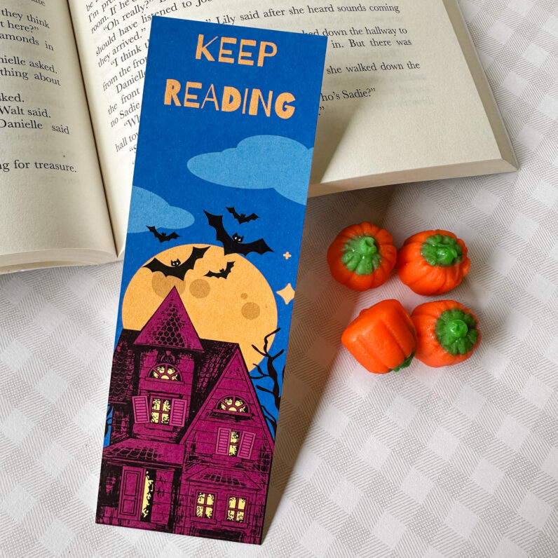 halloween bookmark with purple house, yellow moon, black bats against a night sky, and the words "keep reading"