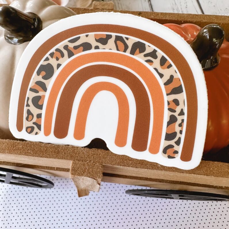 Rainbow vinyl sticker with alternating bows of leopard and brown, and peachy-orange.